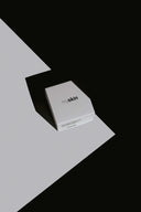 Caja de crema hidratante facial myskin Barcelona sobre un fondo geométrico en blanco y negro, con un juego de luces y sombras.